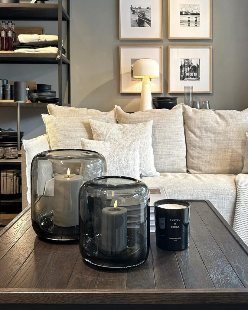 Sofa mit Kissen, Windlichtern und Wohnaccessoires bei COSMAN-Interior
